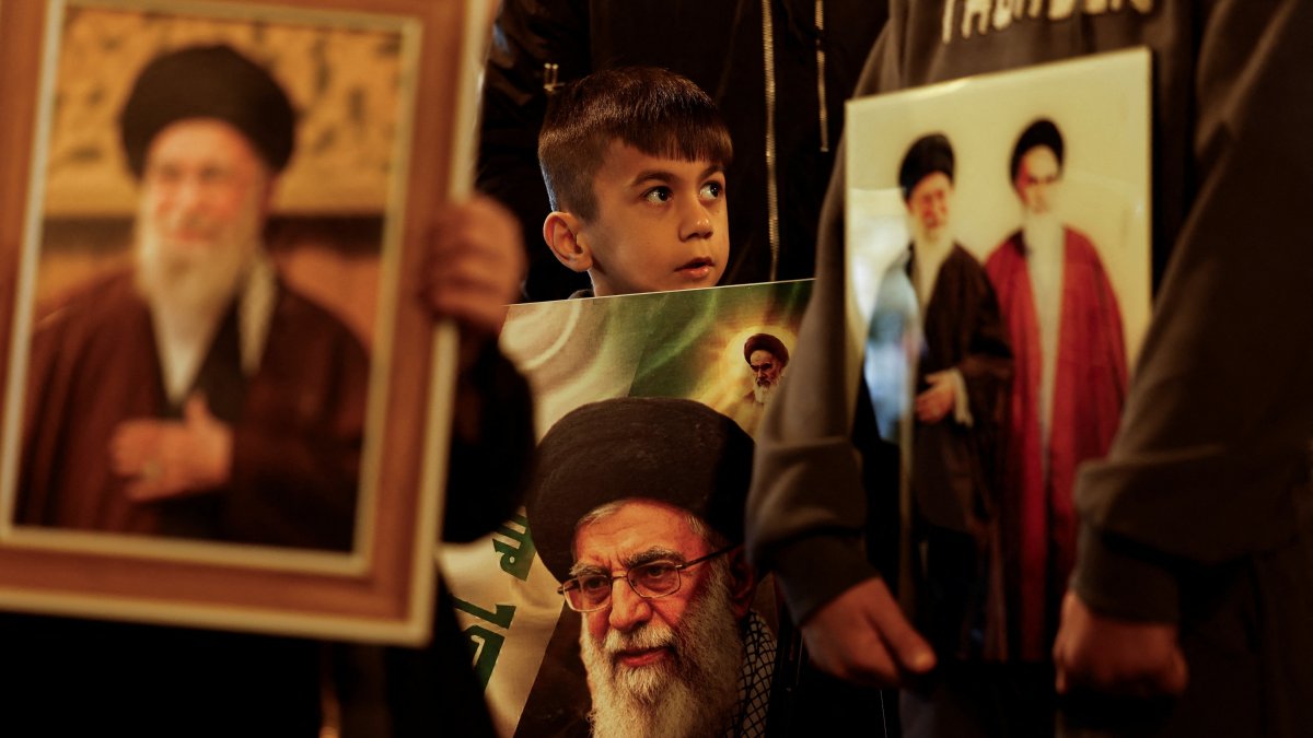 A boy carries a portrait of Iranian Supreme Leader Ayatollah Ali Khamenei during a symbolic funeral procession, following his death in Israeli-U.S. airstrikes, Najaf, Iraq, March 3, 2026. (Reuters Photo)
