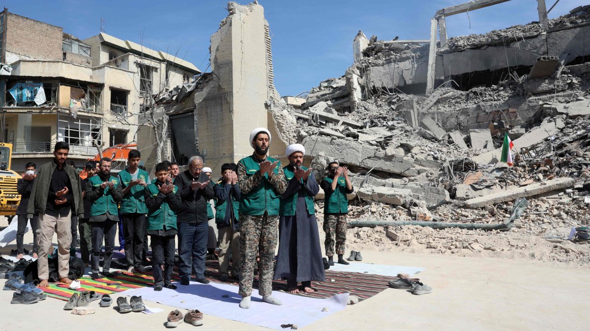 Iranian clerics and volunteers who are helping clear the streets pray next to the rubble of a police station destroyed in Israeli airstrikes in central Tehran, Iran, March 4, 2026. (AFP Photo)