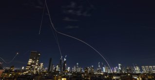 Rocket trails from an interception by the Iron Dome missile defense system are pictured over Tel Aviv, Israel, March 1, 2026. (AFP Photo)