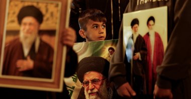 A boy carries a portrait of Iranian Supreme Leader Ayatollah Ali Khamenei during a symbolic funeral procession, following his death in Israeli-U.S. airstrikes, Najaf, Iraq, March 3, 2026. (Reuters Photo)