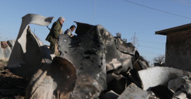 Iranian Kurdish Peshmerga members of the Kurdistan Democratic Party (KDPI) walk past debris from an Iranian attack, Koye, northern Iraq, March 3, 2026. (AFP Photo)