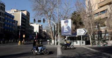 Vehicles pass by a sign in tribute to Iran's late Supreme Leader Ayatollah Ali Khamenei on a street in Tehran, Iran, March 4, 2026. (Reuters Photo)