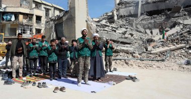 Iranian clerics and volunteers who are helping clear the streets pray next to the rubble of a police station destroyed in Israeli airstrikes in central Tehran, Iran, March 4, 2026. (AFP Photo)
