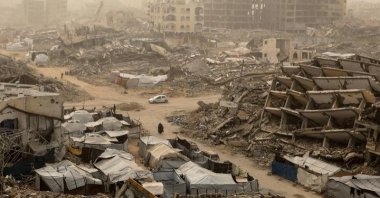 Palestinians walk among the rubble during a dust storm in southern Gaza City, Palestine, Feb. 14, 2026. (DHA Photo)