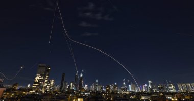 Rocket trails from an interception by the Iron Dome missile defense system are pictured over Tel Aviv, Israel, March 1, 2026. (AFP Photo)