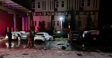 People gather near debris from a drone that fell onto a building near Irbil airport, amid the U.S.-Israeli conflict with Iran, in the Ankawa district of Irbil, Iraq, March 4, 2026. (Reuters Photo)