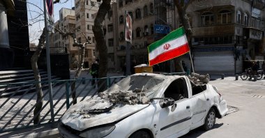 An Iranian flag is mounted on a damaged car following a strike on a police station, amid the U.S.-Israeli conflict with Iran, in Tehran, Iran, March 4, 2026. (Reuters Photo)