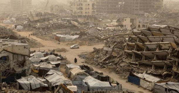 Palestinians walk among the rubble during a dust storm in southern Gaza City, Palestine, Feb. 14, 2026. (DHA Photo)
