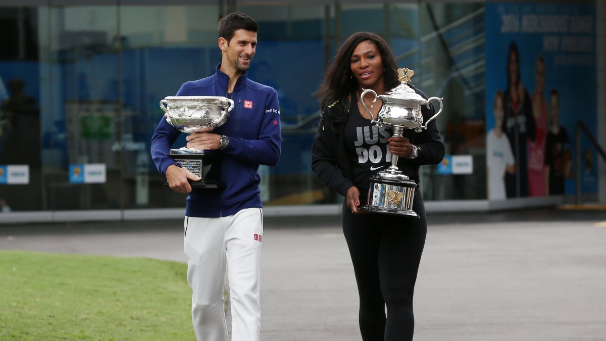 Serena Williams (R) and Novak Djokovic carry their trophies as they arrive for the official draw at the Australian Open tennis championships, Melbourne, Australia, Jan. 15, 2016. (AP Photo)