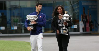 Serena Williams (R) and Novak Djokovic carry their trophies as they arrive for the official draw at the Australian Open tennis championships, Melbourne, Australia, Jan. 15, 2016. (AP Photo)