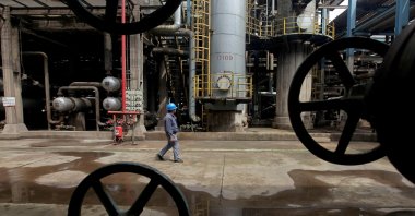 A worker walks past oil pipes at a refinery in Wuhan, Hubei province, China, March 23, 2012. (Reuters File Photo)