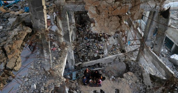 A displaced Palestinian family gather to sit for the "iftar" fast-breaking meal during the Muslim holy month of Ramadan, amidst the destruction in Bureij refugee camp in the central Gaza Strip, Feb. 25, 2026. (AFP File Photo)