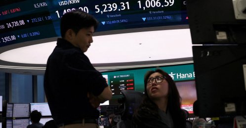 Currency dealers talk in front of an electronic board displaying the Korea Composite Stock Price Index (KOSPI), the exchange rate between the U.S. Dollar and South Korean Won and the Korea Securities Dealers Automated Quotations (KOSDAQ) at the dealing room of a bank in Seoul, South Korea, March 4, 2026. (Reuters Photo)