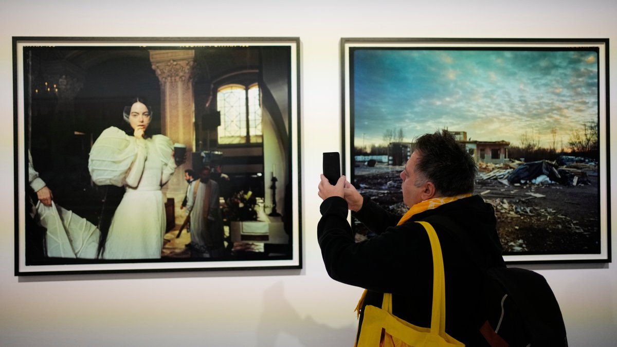 A visitor takes a picture of a portrait of actress Emma Stone at an exhibition of images by Yorgos Lanthimos, Athens, Greece, March 6, 2026. (AP Photo)