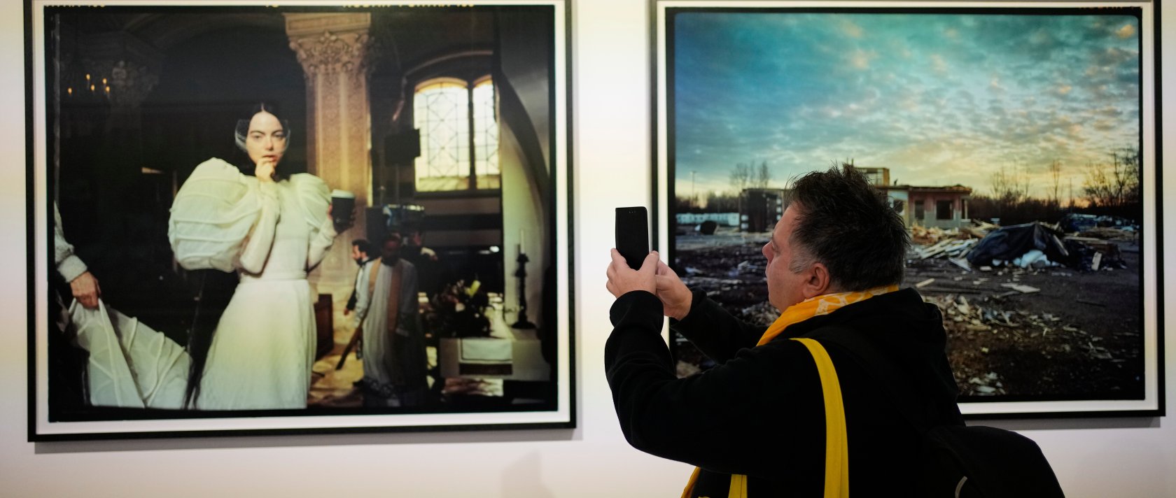 A visitor takes a picture of a portrait of actress Emma Stone at an exhibition of images by Yorgos Lanthimos, Athens, Greece, March 6, 2026. (AP Photo)