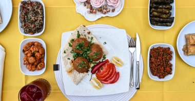 Adana içli köfte served with mezes on the table, Adana, southern Türkiye, Aug. 14, 2025. (AA Photo)