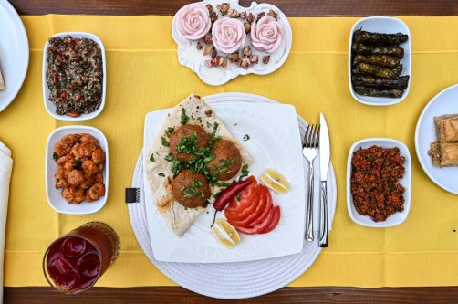 Adana içli köfte served with mezes on the table, Adana, southern Türkiye, Aug. 14, 2025. (AA Photo)
