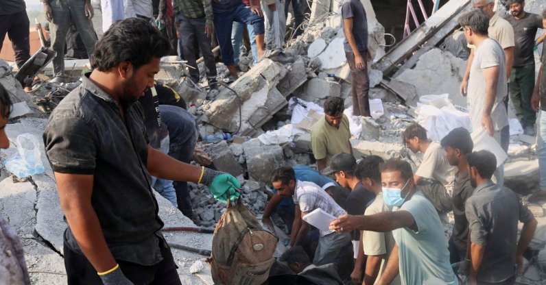 A man holds a child's backpack as rescue workers and residents search through the rubble in the aftermath of what Iranian officials said was an Israeli-U.S. strike on a girls' elementary school, Minab, Iran, Feb. 28, 2026. (AP Photo)