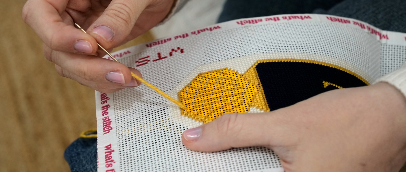 Emma MacTaggart, founder of What's the Stitch needlepoint business, works on a needlepoint in her studio, New York, U.S., Feb. 9, 2026. (AP Photo)