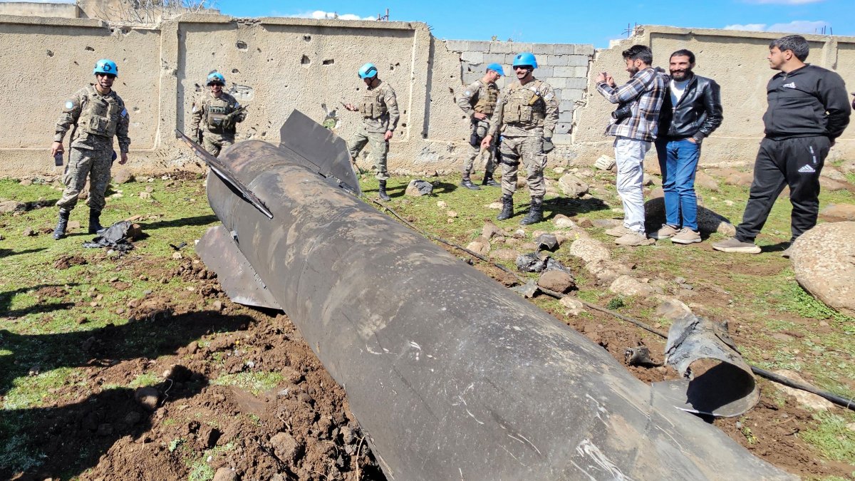 U.N. peacekeepers and civilians stand near the wreckage of an Iranian rocket that was reportedly intercepted by Israeli forces in the southern Syrian countryside of Quneitra, near the Israeli-occupied Golan Heights, Syria, Feb. 28, 2026. (AFP Photo)