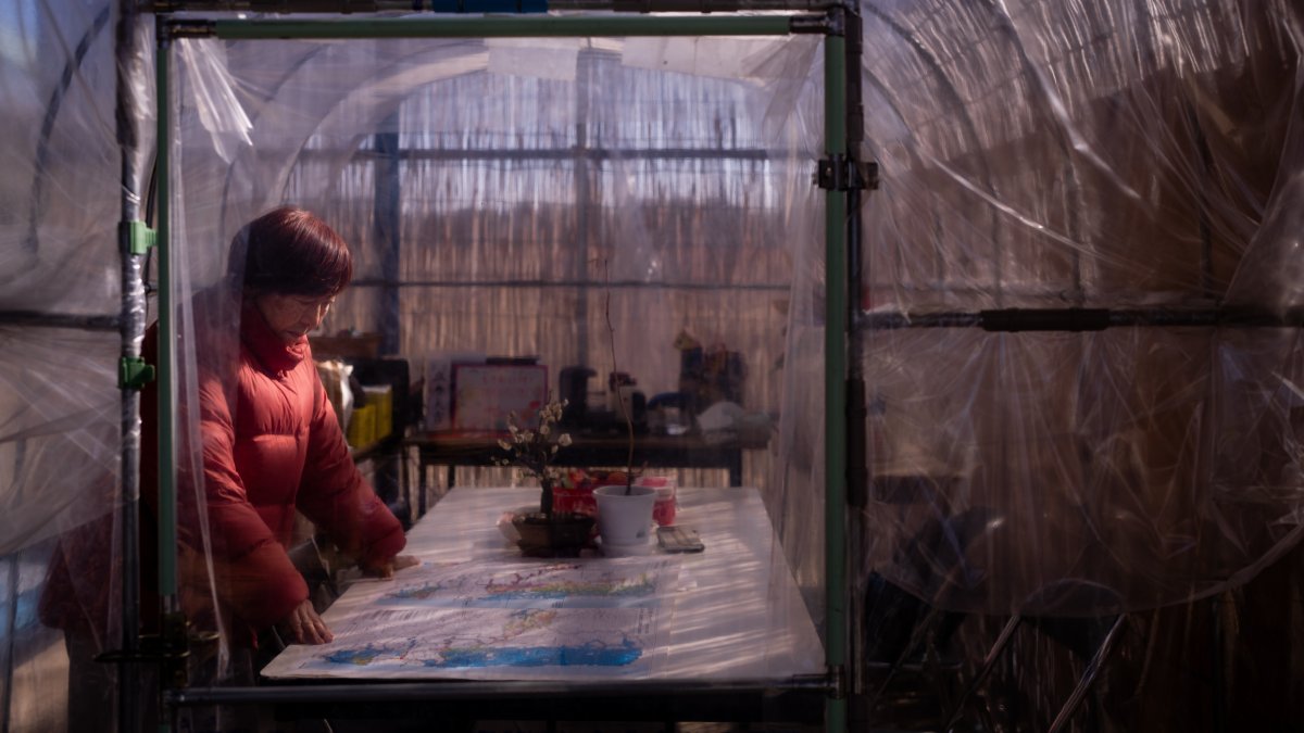 Tomoko Kobayashi looks at a color-coded map of radiation levels created by local residents during an interview near a radiation monitoring lab, Odaka, Japan, Feb. 13, 2026. (AP Photo)