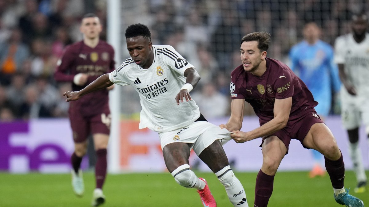 Manchester City's Nico Gonzalez (R) pulls the shorts of Real Madrid's Vinicius Junior during the Champions League playoff second-leg match at Santiago Bernabeu Stadium, Madrid, Spain, Feb. 19, 2025. (AP Photo)