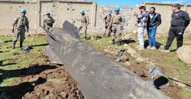 U.N. peacekeepers and civilians stand near the wreckage of an Iranian rocket that was reportedly intercepted by Israeli forces in the southern Syrian countryside of Quneitra, near the Israeli-occupied Golan Heights, Syria, Feb. 28, 2026. (AFP Photo)