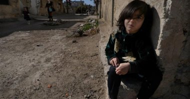 A Syrian girl sits next to her parents' house, in an alley that was hit by the sarin strike during a 2013 chemical weapons attack that was blamed on then Syrian regime leader Bashar Assad's forces, in the Zamalka neighborhood, Damascus, Syria, Dec. 25, 2024. (AP Photo)