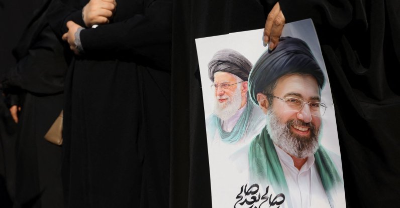 A woman holds an image of Iran's new supreme leader, Mojtaba Khamenei, alongside late Iranian Supreme Leader Ayatollah Ali Khamenei, during a funeral ceremony for the Iranian military commanders who were killed in strikes, amid the U.S.-Israeli conflict with Iran, in Tehran, Iran, March 11, 2026. (Reuters Photo)