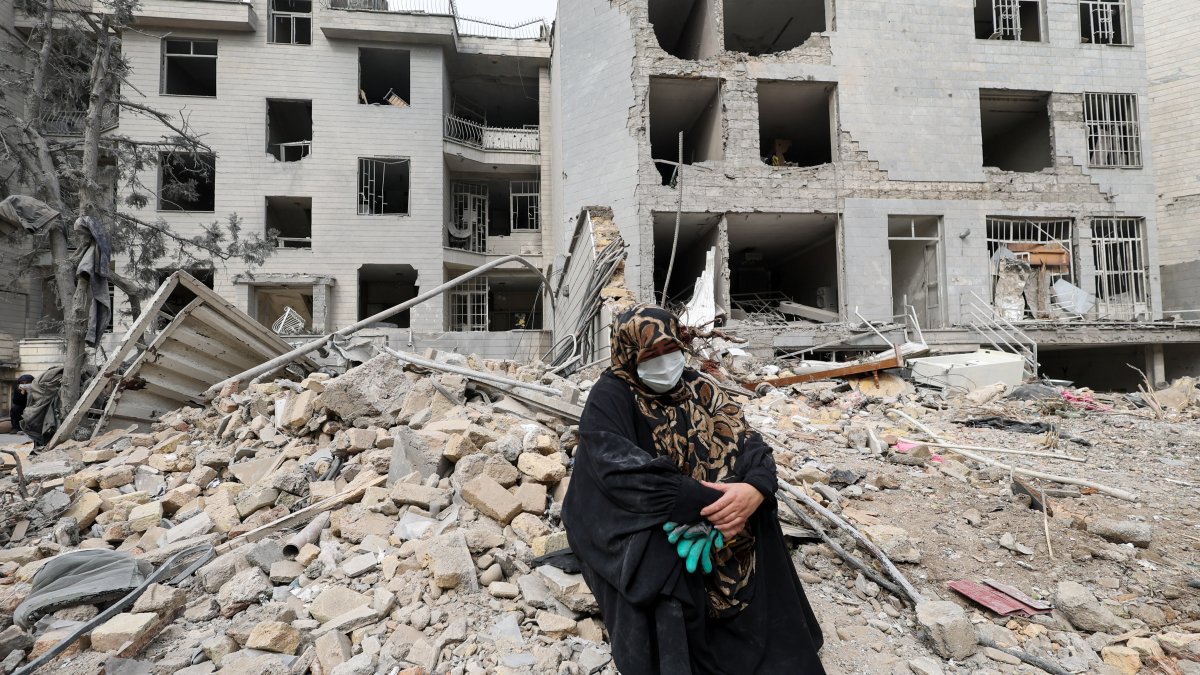 A woman sits outside her destroyed apartment after it was damaged by an Israeli airstrike, in Tehran, Iran, March 12, 2026. (Reuters Photo)