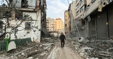 A man walks amid damaged buildings following overnight Israeli airstrikes in the Mcharafieh neighbourhood of Beirut, Lebanon, March 12, 2026. (AFP Photo)