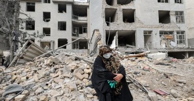 A woman sits outside her destroyed apartment after it was damaged by an Israeli airstrike, in Tehran, Iran, March 12, 2026. (Reuters Photo)