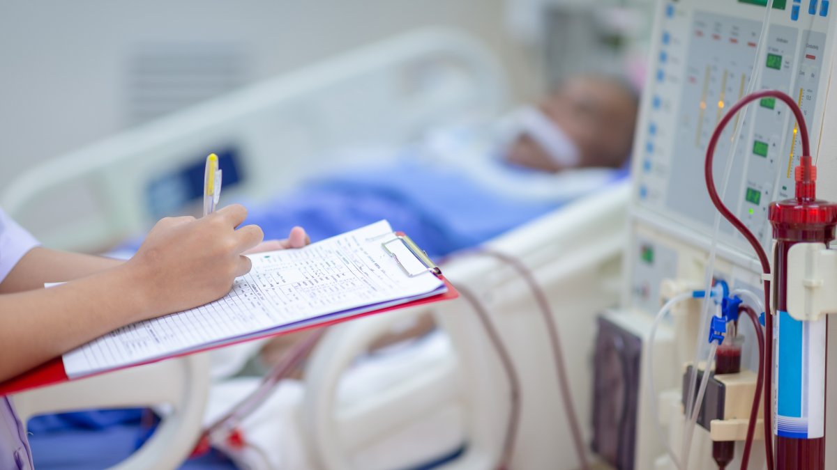 A dialysis nurse monitors the machine while a patient receives treatment. (Shuterstock Photo) 