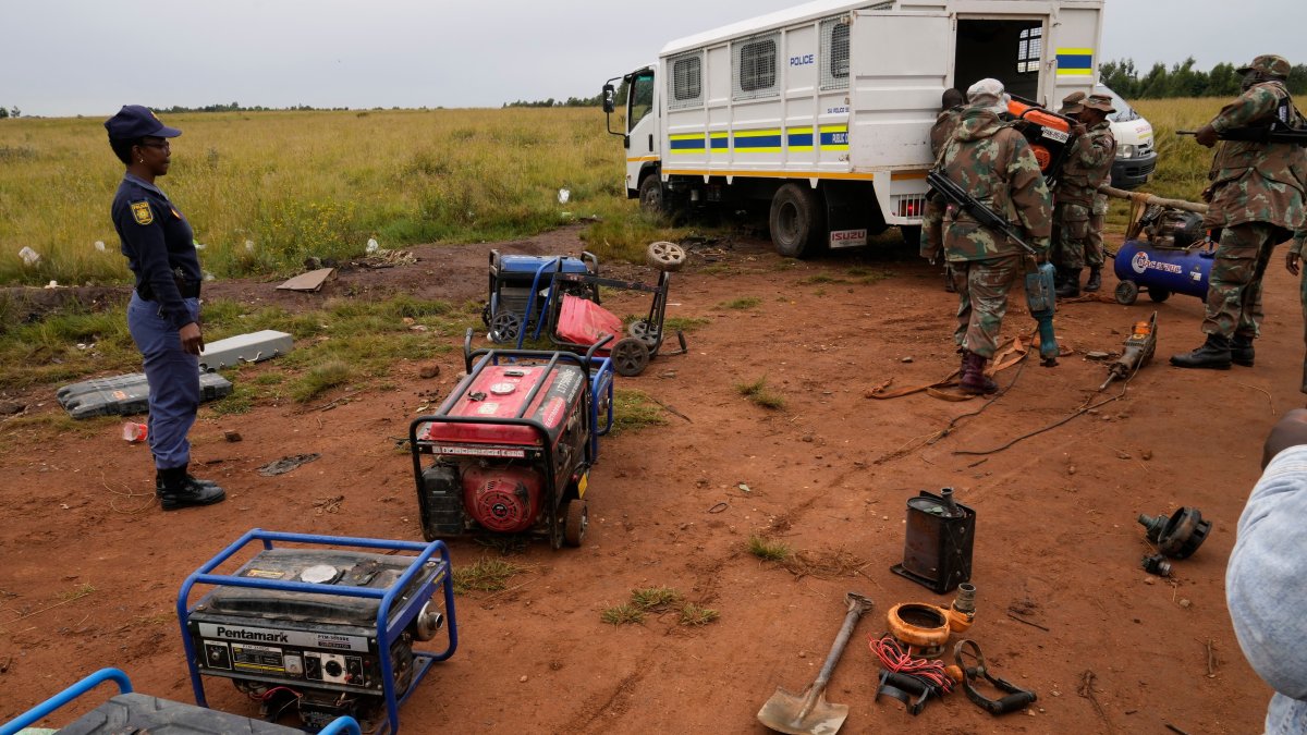 South African National Defense Force soldiers and police officers load recovered generators and machinery left behind by illegal miners, during a patrol in Randfontein, Johannesburg, South Africa, March 12, 2026. (AP Photo)