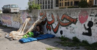 Displaced children sit with bedding, set up along a roadside, following an escalation between Hezbollah and Israel amid the U.S.-Israeli conflict with Iran, in Beirut, Lebanon, March 13, 2026. (Reuters Photo)