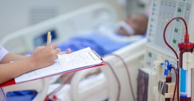 A dialysis nurse monitors the machine while a patient receives treatment. (Shuterstock Photo) 