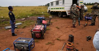 South African National Defense Force soldiers and police officers load recovered generators and machinery left behind by illegal miners, during a patrol in Randfontein, Johannesburg, South Africa, March 12, 2026. (AP Photo)