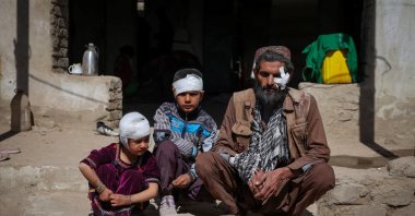 Mohammad Feraidoon, his son Aqeel and daughter Nazanin, who were injured in what the Taliban said was a Pakistani air strike, sit outside their damaged house on the outskirts of Kabul, Afghanistan, March 13, 2026. (Reuters Photo)