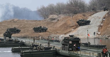 U.S. Stryker infantry carrier vehicles cross a river over a floating bridge as they participate in a combined maneuver training with wet gap crossing during the 2026 South Korea-U.S. Freedom Shield military exercise in Yeoncheon, South Korea, March 14, 2026. (AFP Photo)