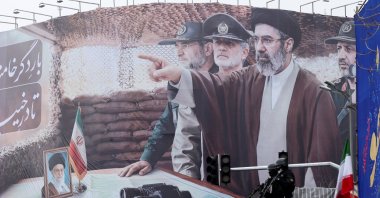Security personnel stand guard in front of a banner with an image of Iran's new Supreme Leader Mojtaba Khamenei and his father, Iran's late Supreme Leader Ayatollah Ali Khamenei, Tehran, Iran, March 13, 2026. (Reuters Photo)