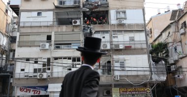 An Ultra Orthodox Jewish man looks on as Israeli rescuers work at the scene of an Iranian strike in Tel Aviv, Israel, March 15, 2026. (EPA Photo)