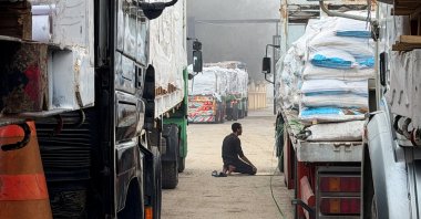 An Egyptian man prays next to trucks carrying humanitarian aid and fuel lined up at the Rafah border to cross into the Gaza Strip, on the Egyptian side, in Rafah, Egypt, Feb. 10, 2026. (Reuters Photo)
