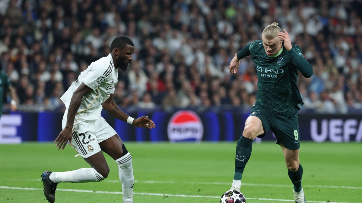 Manchester City's Erling Haaland (R) is challenged by Real Madrid's Antonio Ruediger during the UEFA Champions League last 16 first leg football match at Santiago Bernabeu Stadium, Madrid, Spain, March 11, 2026. (AFP Photo)