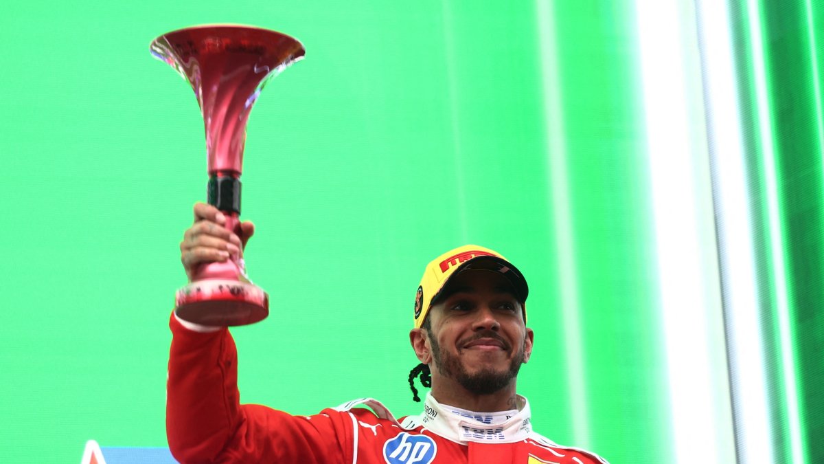 Ferrari's Lewis Hamilton celebrates on the podium with his trophy after finishing third in the Chinese Grand Prix at Shanghai International Circuit, Shanghai, China, March 15, 2026. (Reuters Photo)
