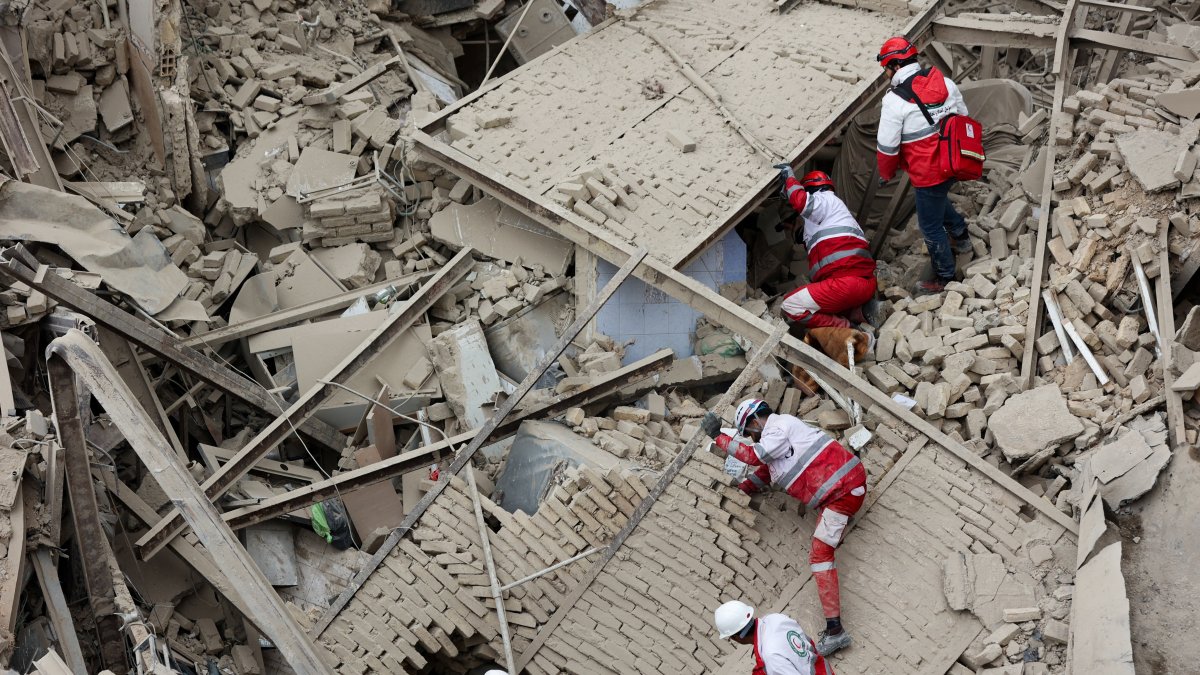 Emergency personnel work at the site of a building destroyed in an Israeli strike, in Tehran, Iran, March 16, 2026. (Reuters Photo)