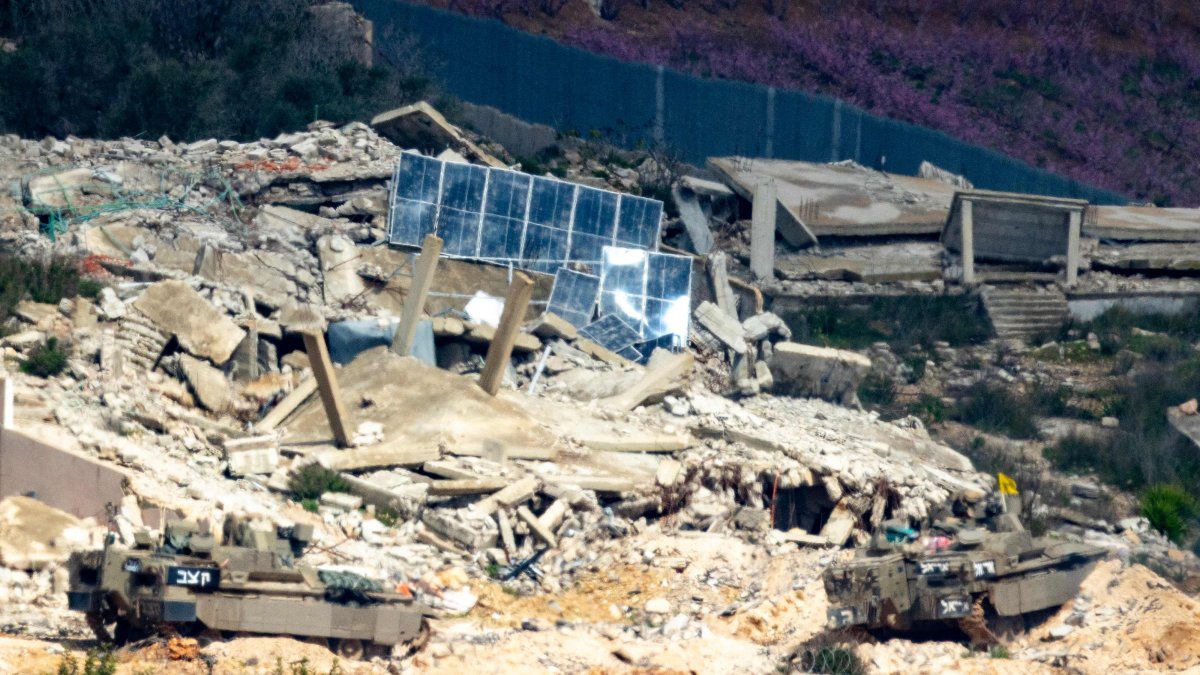 Israeli army fighting vehicles manoeuver across the border inside a destroyed Lebanese village as seen from the Upper Galilee in northern Israel, March 16, 2026. (AFP Photo)