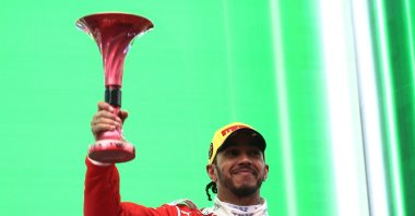 Ferrari's Lewis Hamilton celebrates on the podium with his trophy after finishing third in the Chinese Grand Prix at Shanghai International Circuit, Shanghai, China, March 15, 2026. (Reuters Photo)
