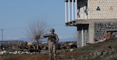 A Turkish soldier stands guard as army and security personnel search a field after a piece of ammunition fell following the interception of a missile launched from Iran by a NATO air defense system, Diyarbakır, Türkiye, March 9, 2026. (Reuters Photo)