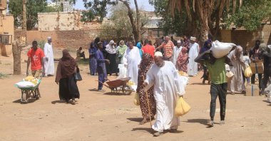 Residents receive aid from WFP at al-Omada neighbourhood of Omdurman, the twin city of Khartoum, March 11, 2026. (AFP Photo)