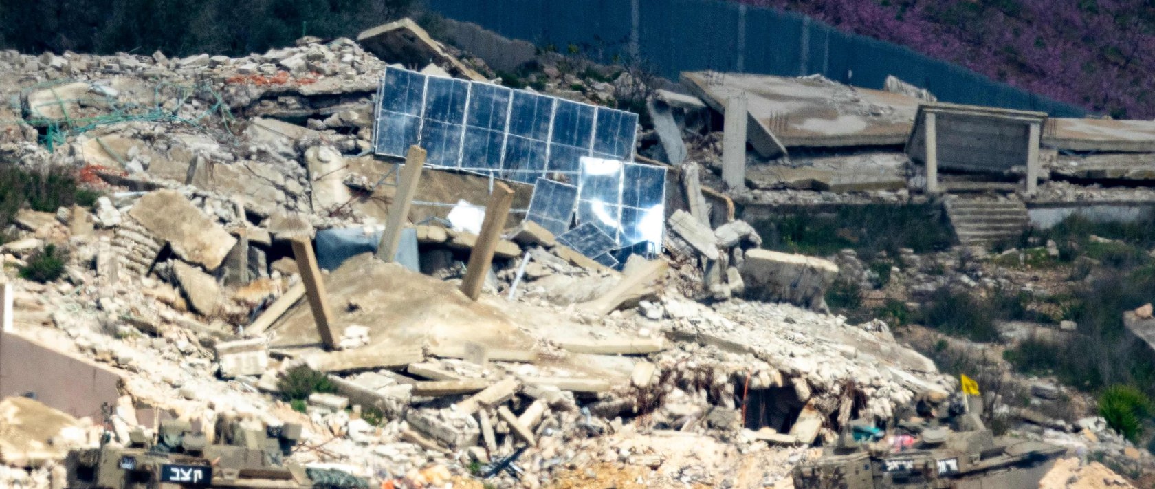 Israeli army fighting vehicles manoeuver across the border inside a destroyed Lebanese village as seen from the Upper Galilee in northern Israel, March 16, 2026. (AFP Photo)